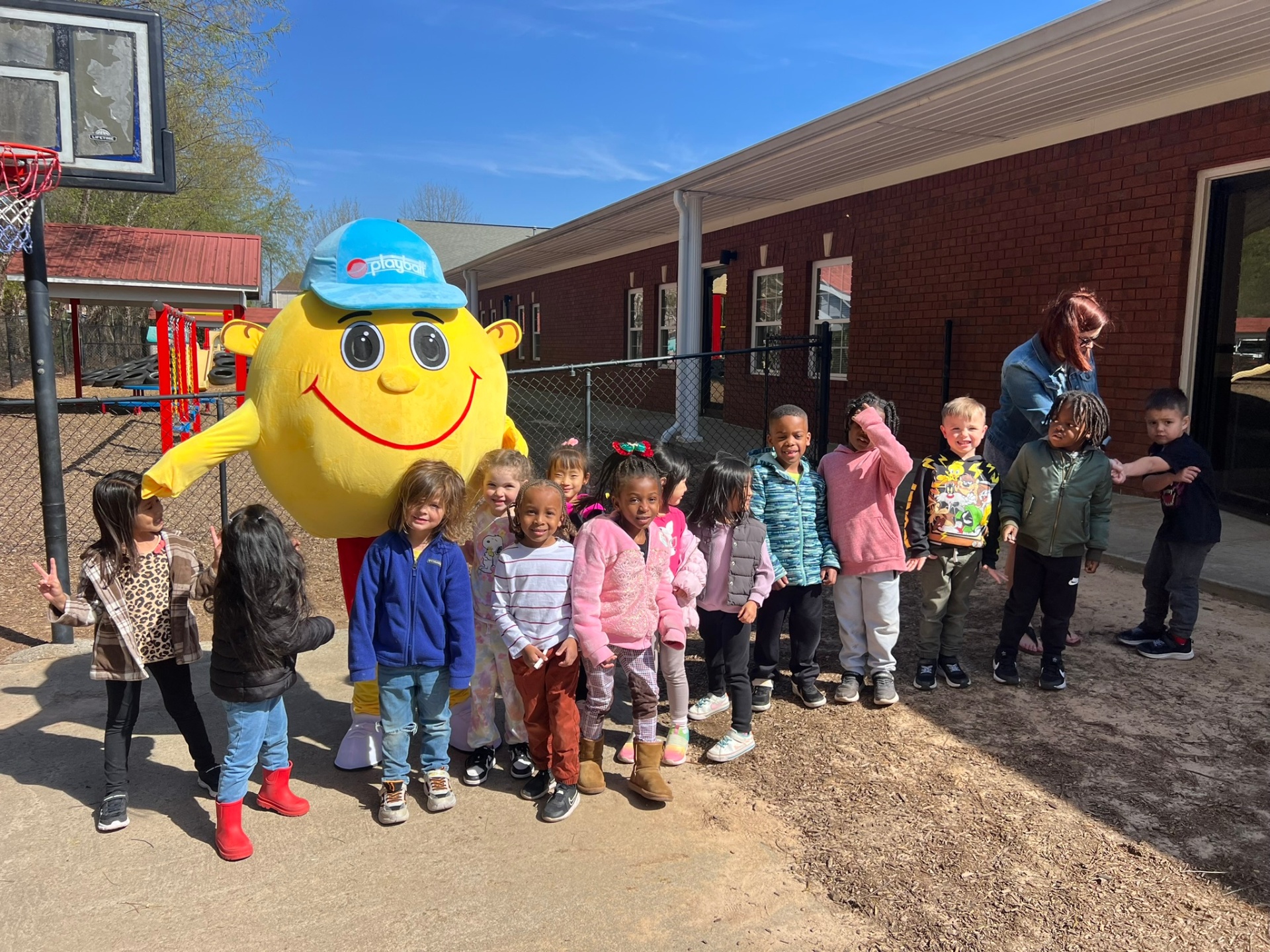 Preschool class posing with the Playball mascot outside