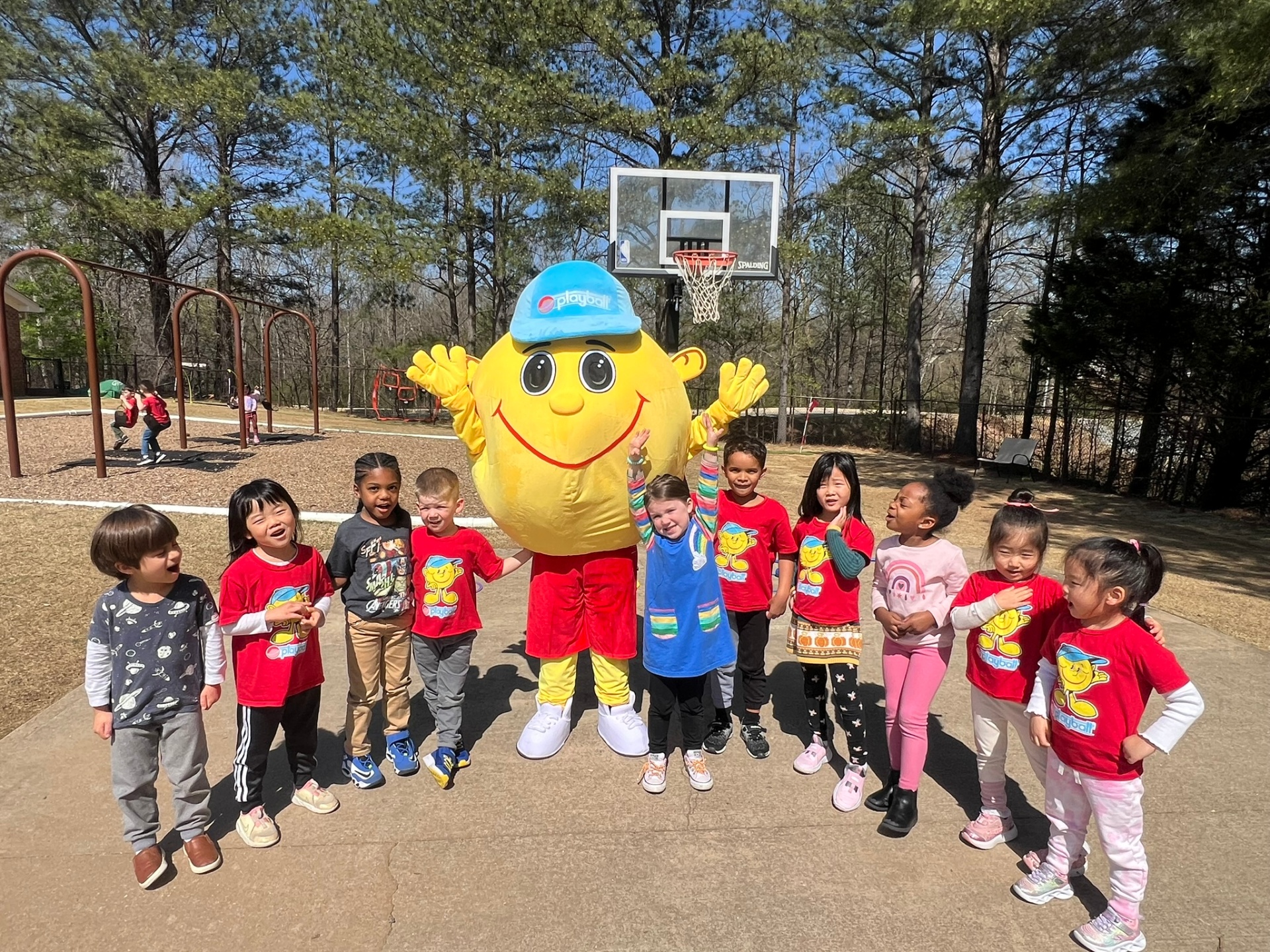Playball mascot celebrating with kids on the court